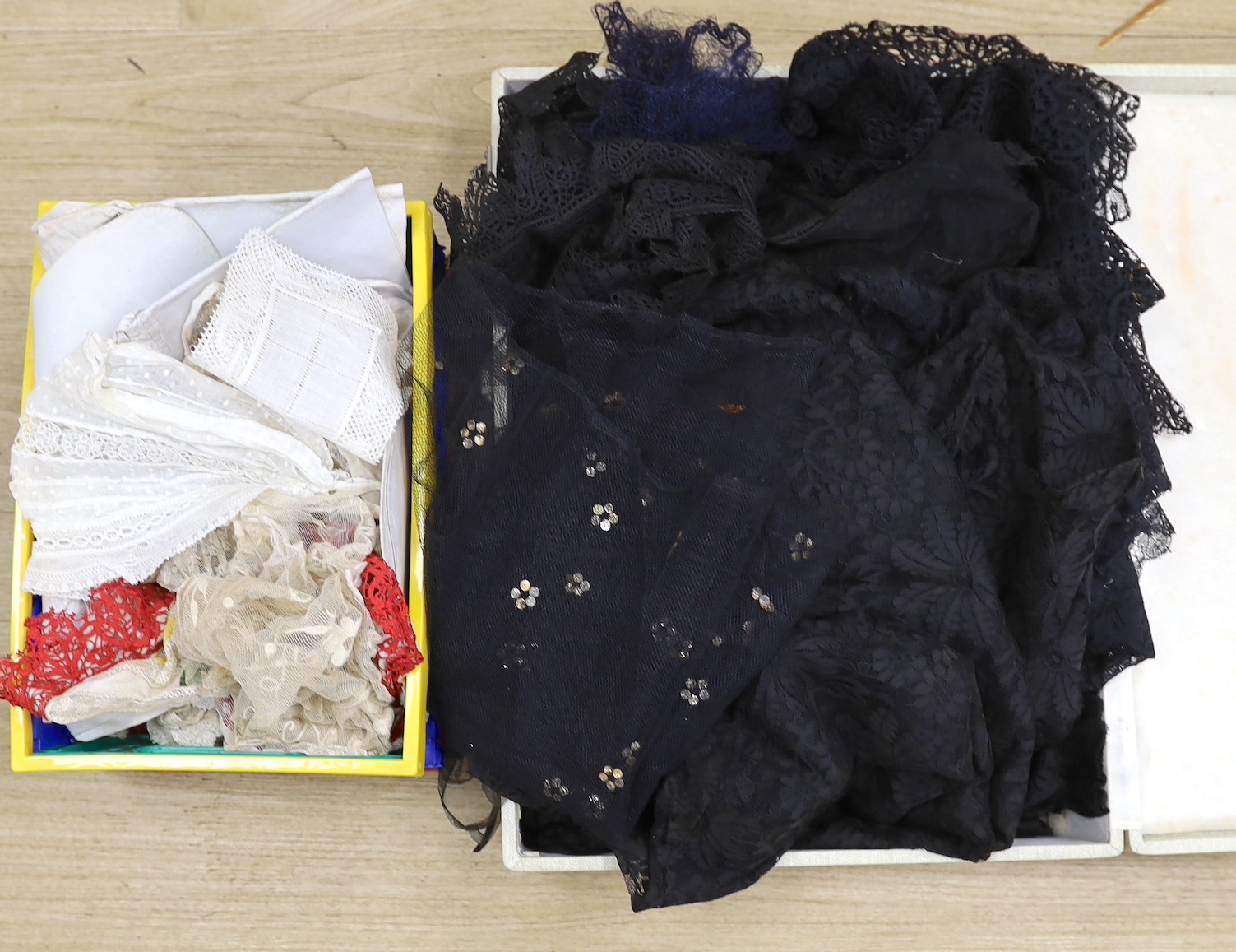 A suitcase of mixed 19th and 20th century black machine and bobbin laces, servants bonnets, cream lace, etc